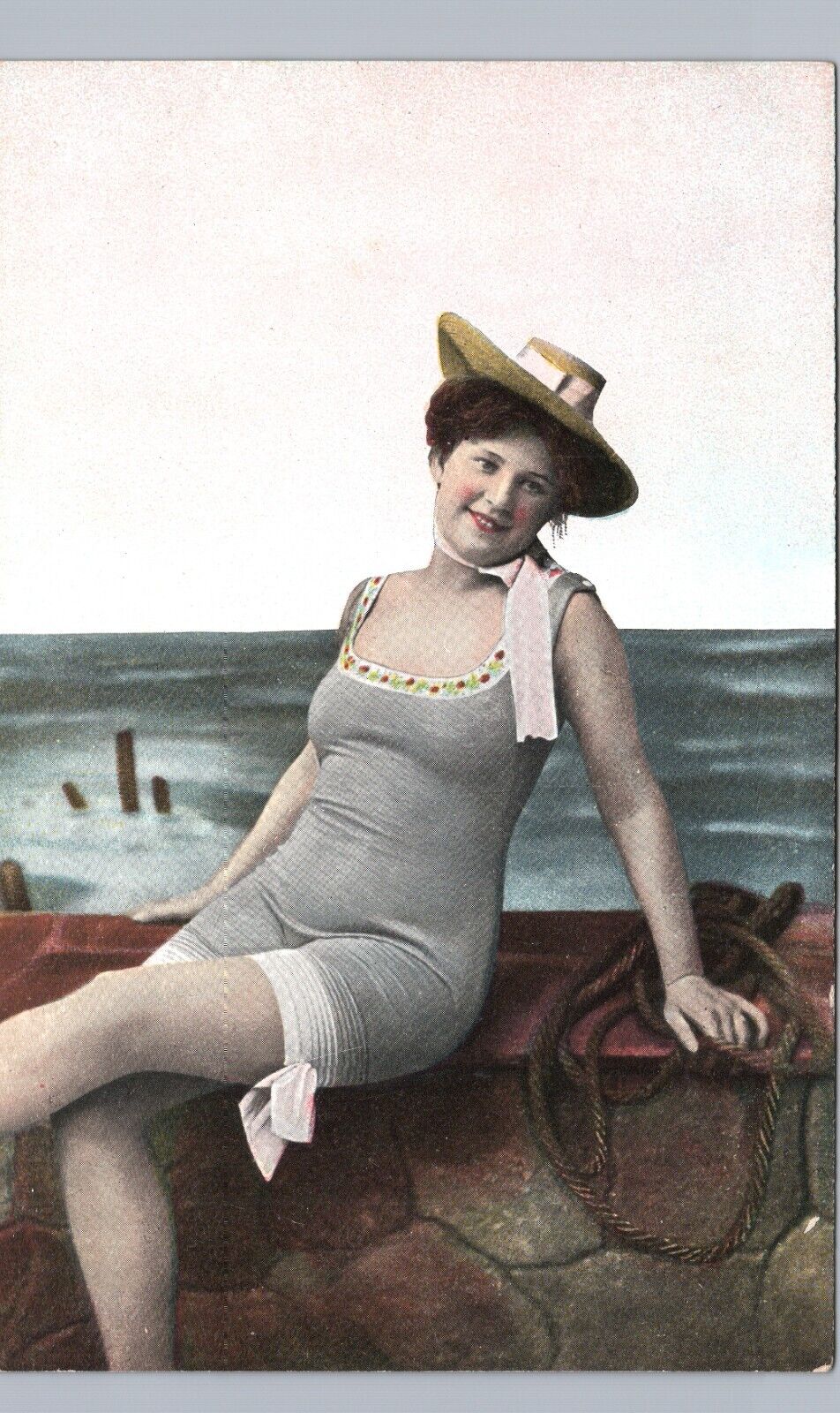 RISQUE BATHING BEAUTY c1920 original antique postcard woman swimming seawall hat