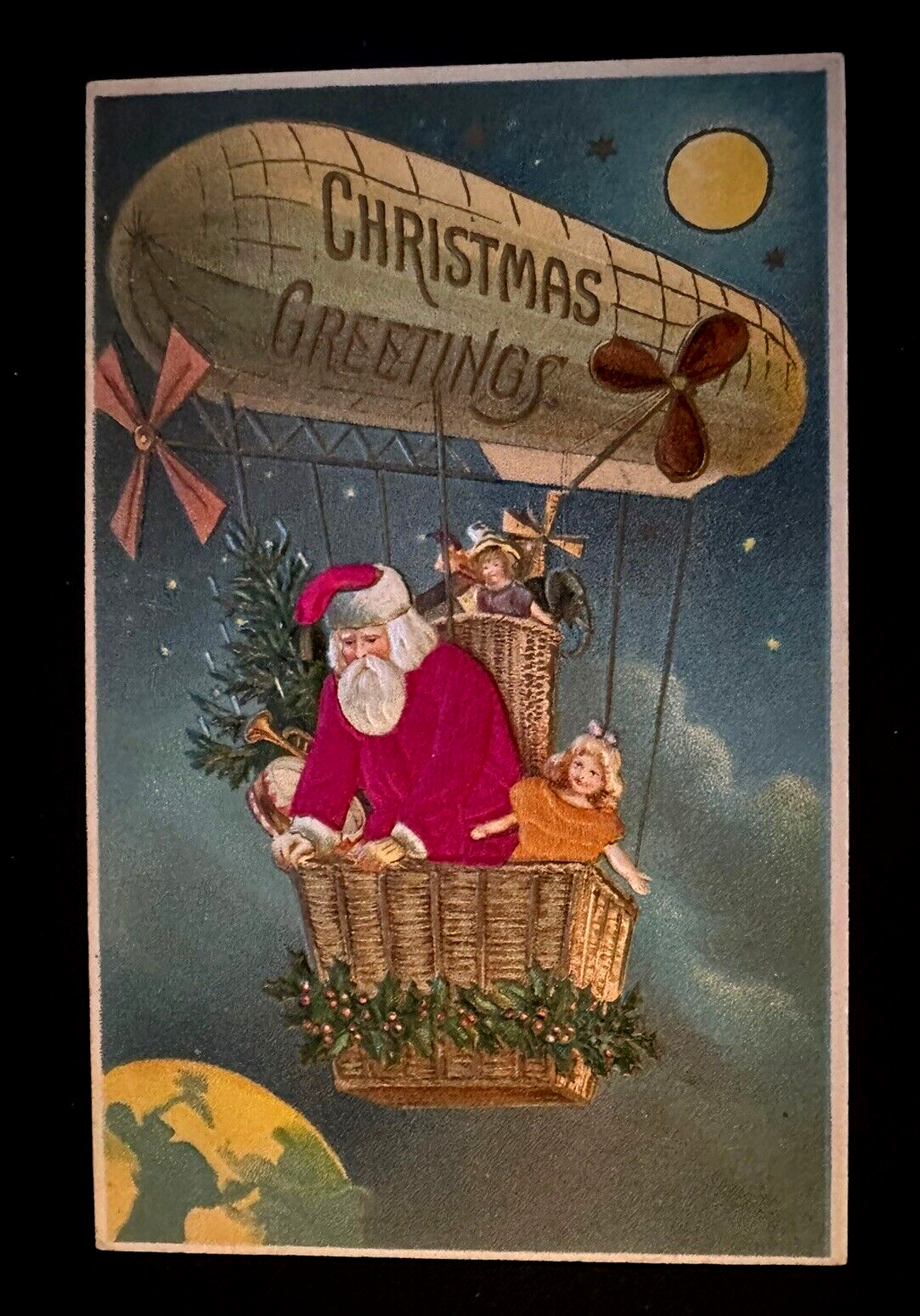 SILK~SANTA CLAUS in HOT AIR BALLOON~BLIMP~ Zeppelin~Toys~Christmas Postcard~k116