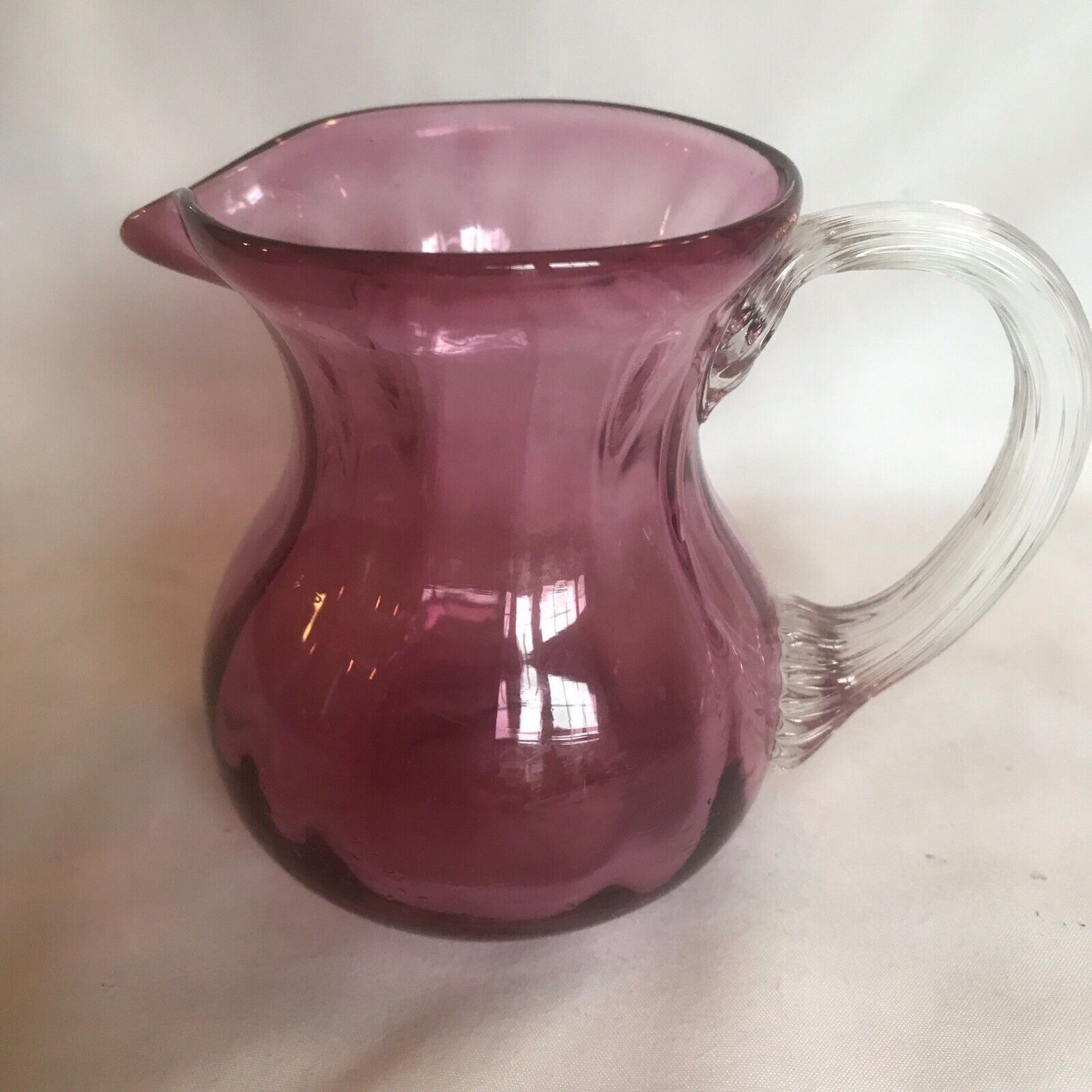 Hand blown Spiral Optic Cranberry glass pitcher with clear fused reeded Handle