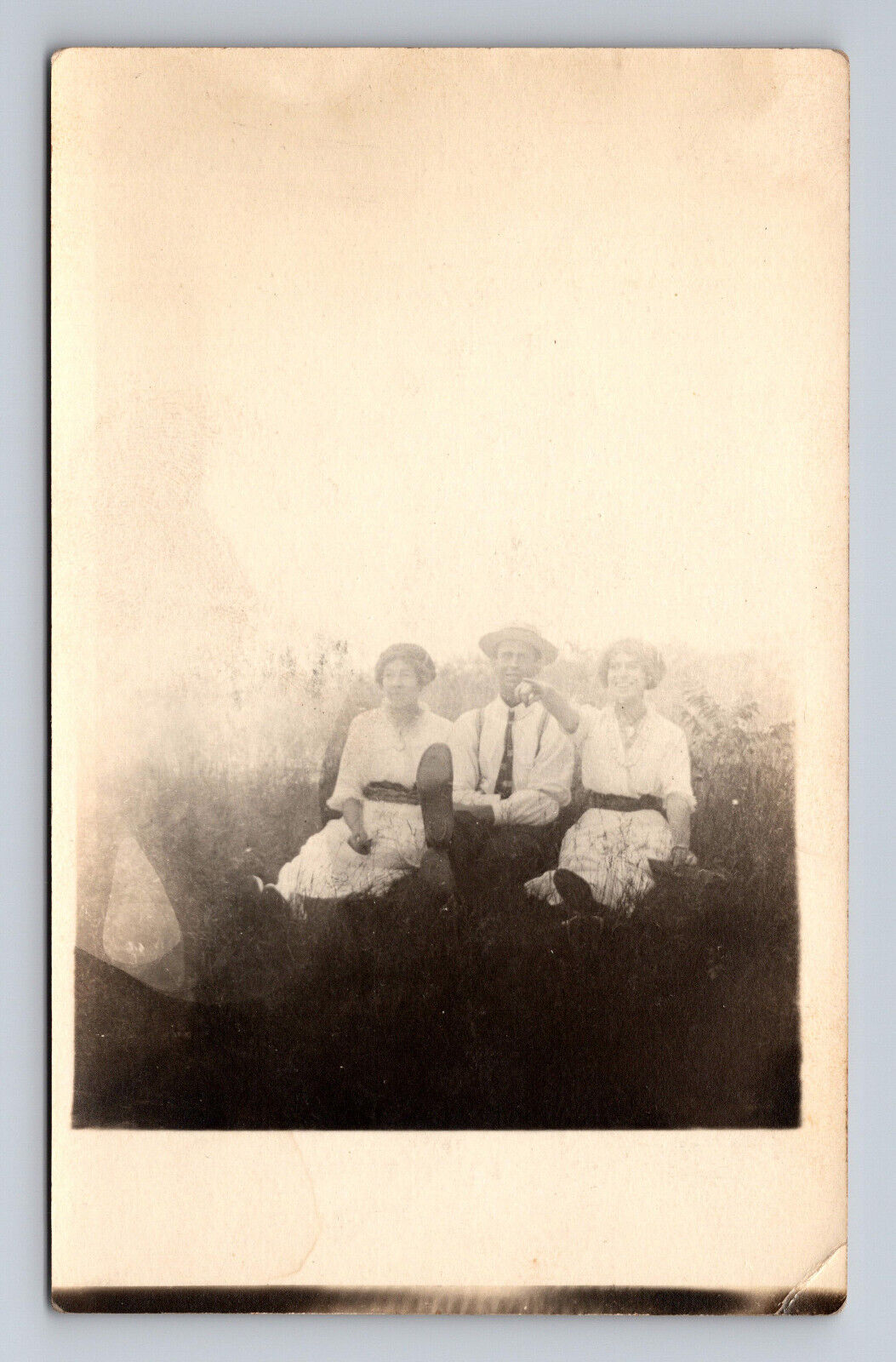 c1904-1918 RPPC Postcard Two Women and Man Sit in Field