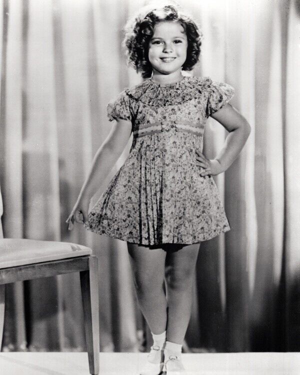 Shirley Temple hand on hip smiling standing by chair 24x36 inch poster