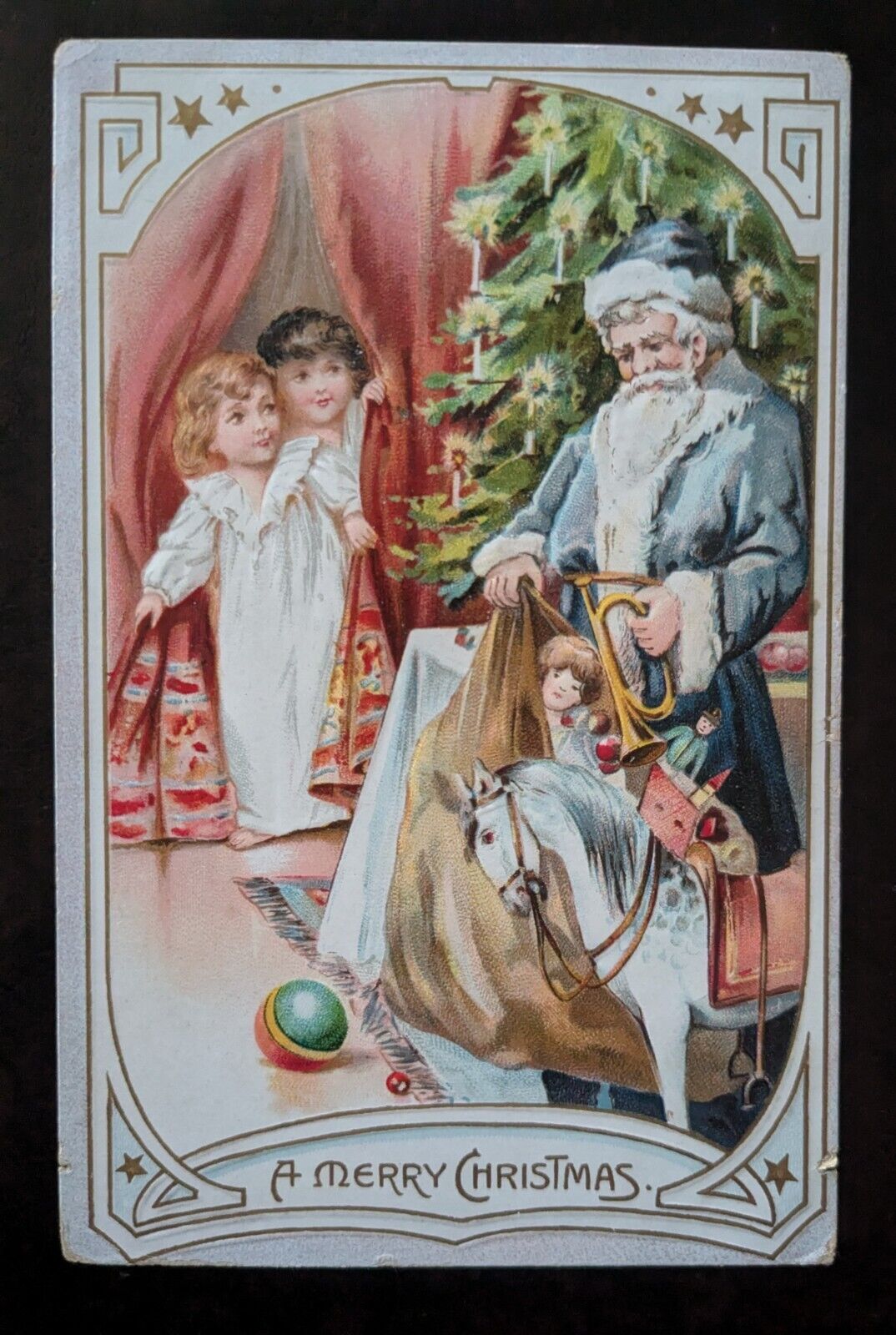 c1910 Blue Robe Santa with Tree Bag of Toys & Kids Merry Christmas postcard Tuck