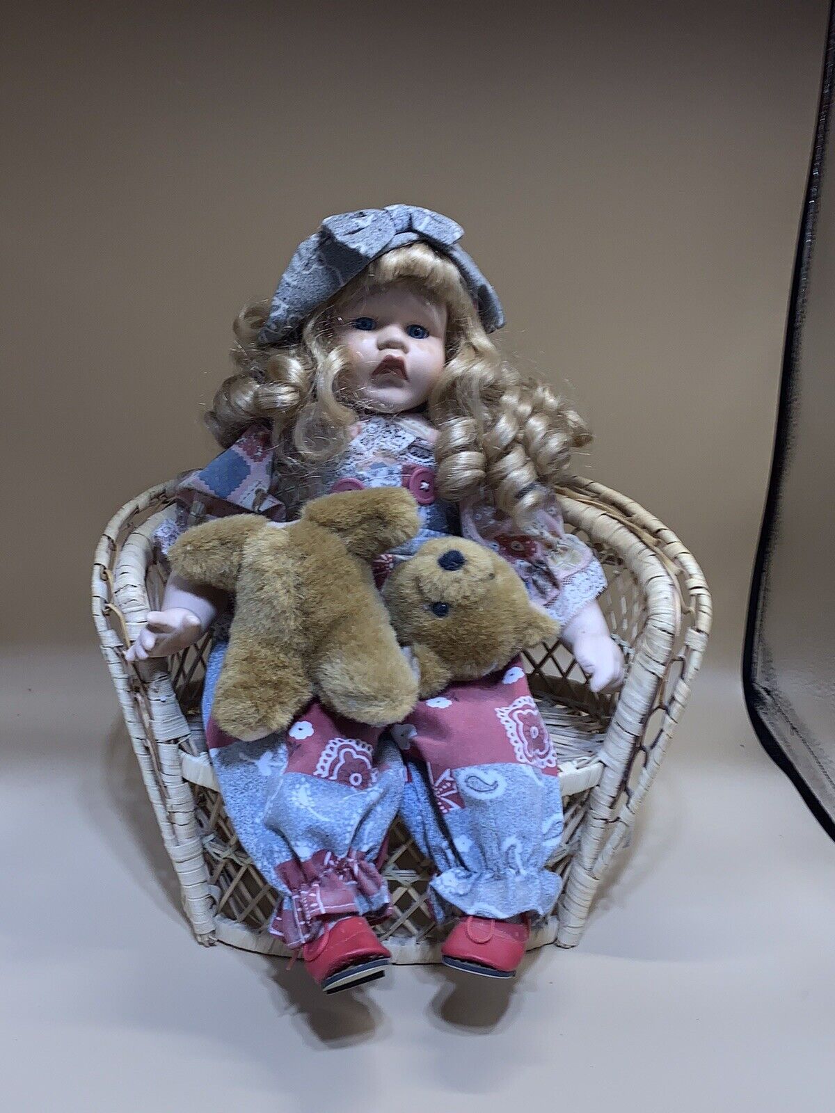 VERY PRETTY DOLL WHOSE BEAR HAS LOST ITS HEAD AND IS CRYING SITTING ON A CHAIR
