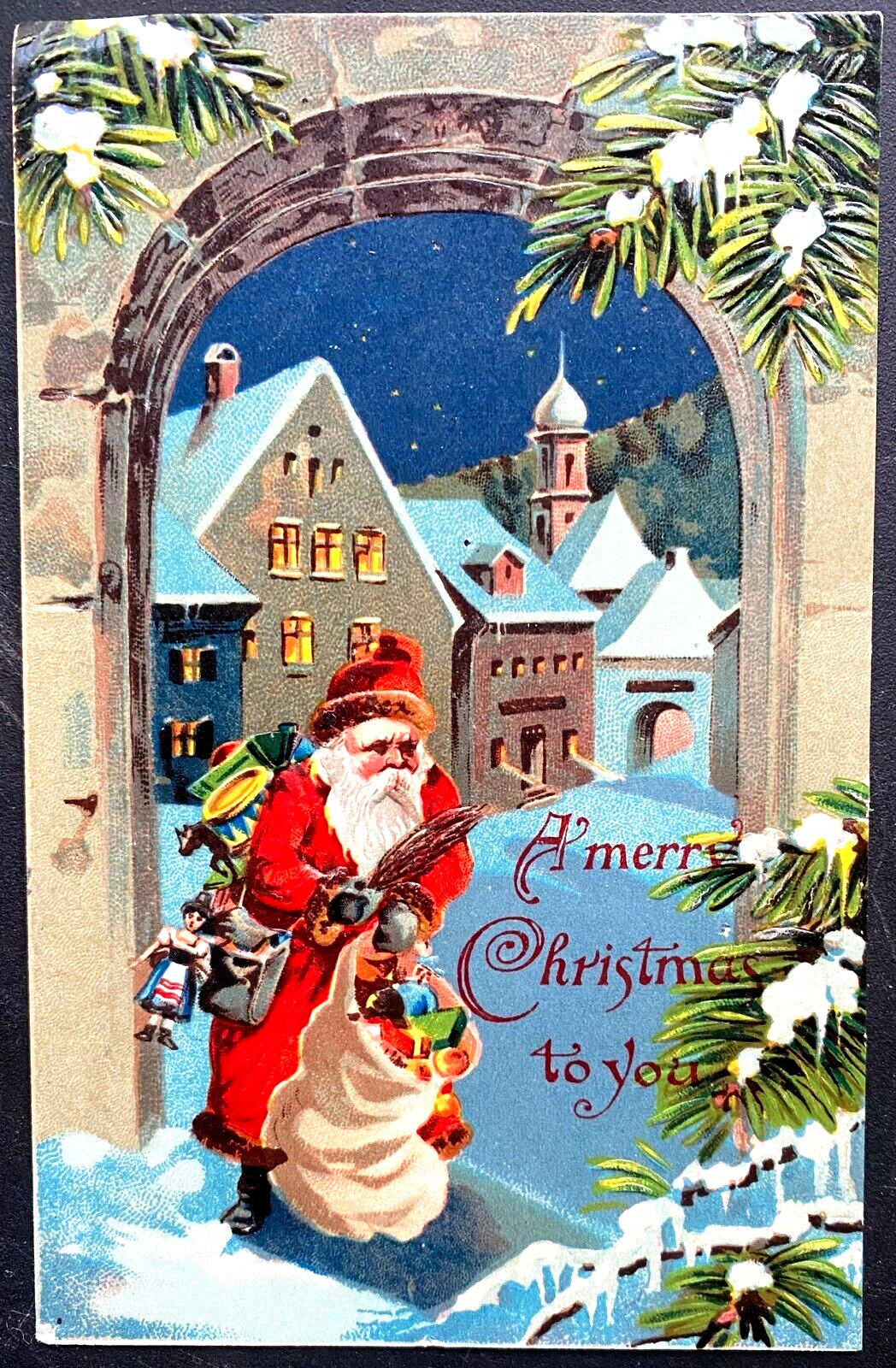 Red Robe Santa Claus Walks Thru Snowy Village with Toys~ Christmas~Postcard~k448