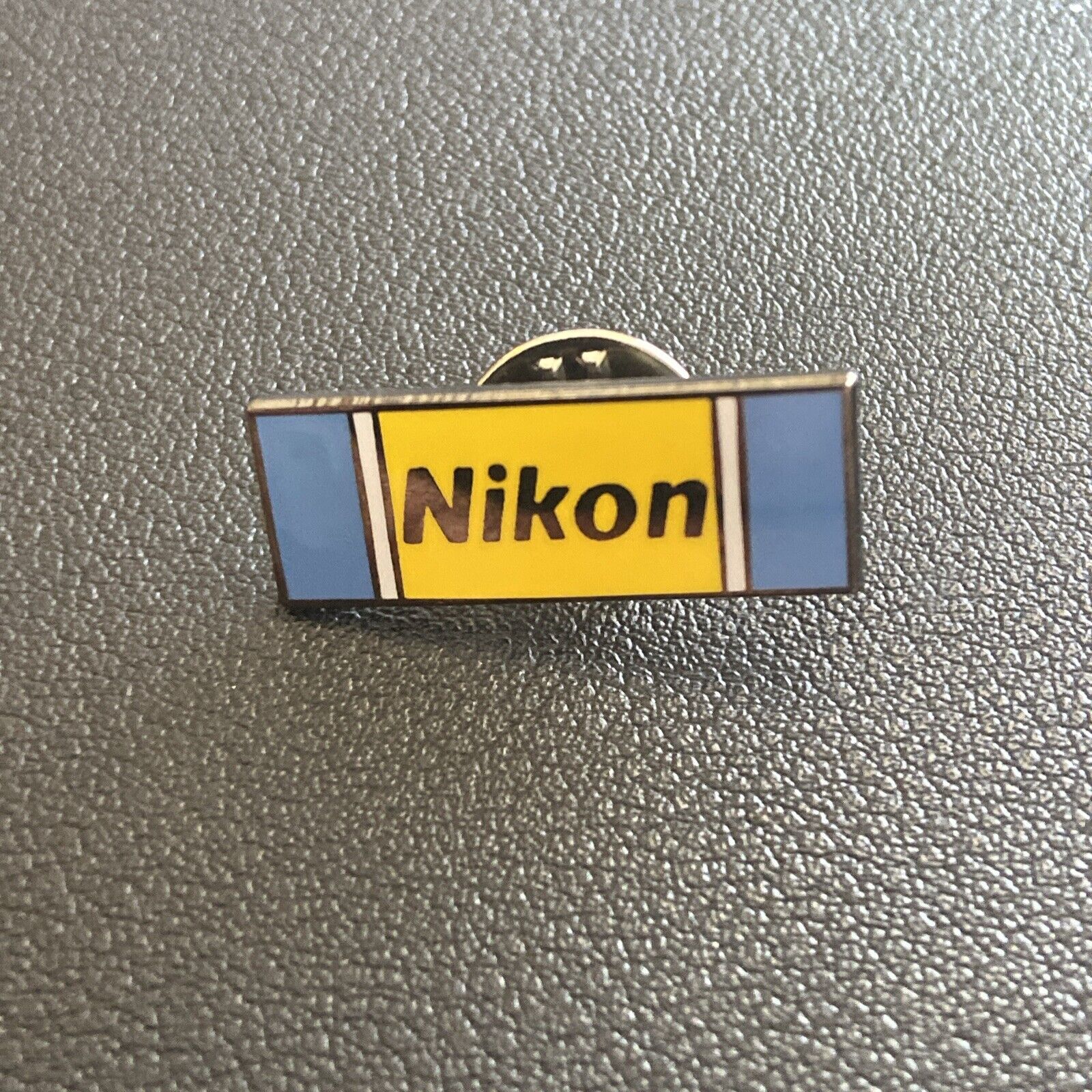 Vintage Nikon Lapel Pin Yellow Blue Black Lettering