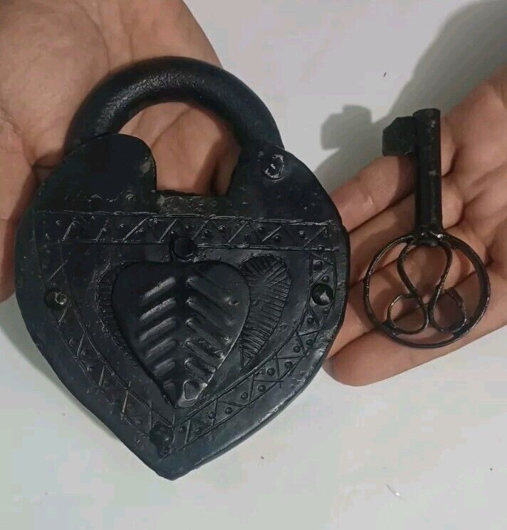 Giant old royal lock in the shape of a large heart with its original black key