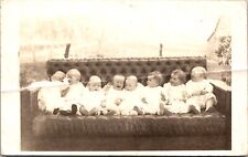Real Photo Postcard Eight Babies Sitting on a Couch picture