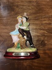 The Natelia Collection Figurine of man and woman sitting on stump on wooden base picture