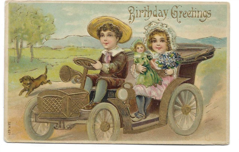 ANTIQUE BIRTHDAY Postcard    BOY IN AUTO, GIRL HOLDING DOLL, PUPPY RUNNING ALONG