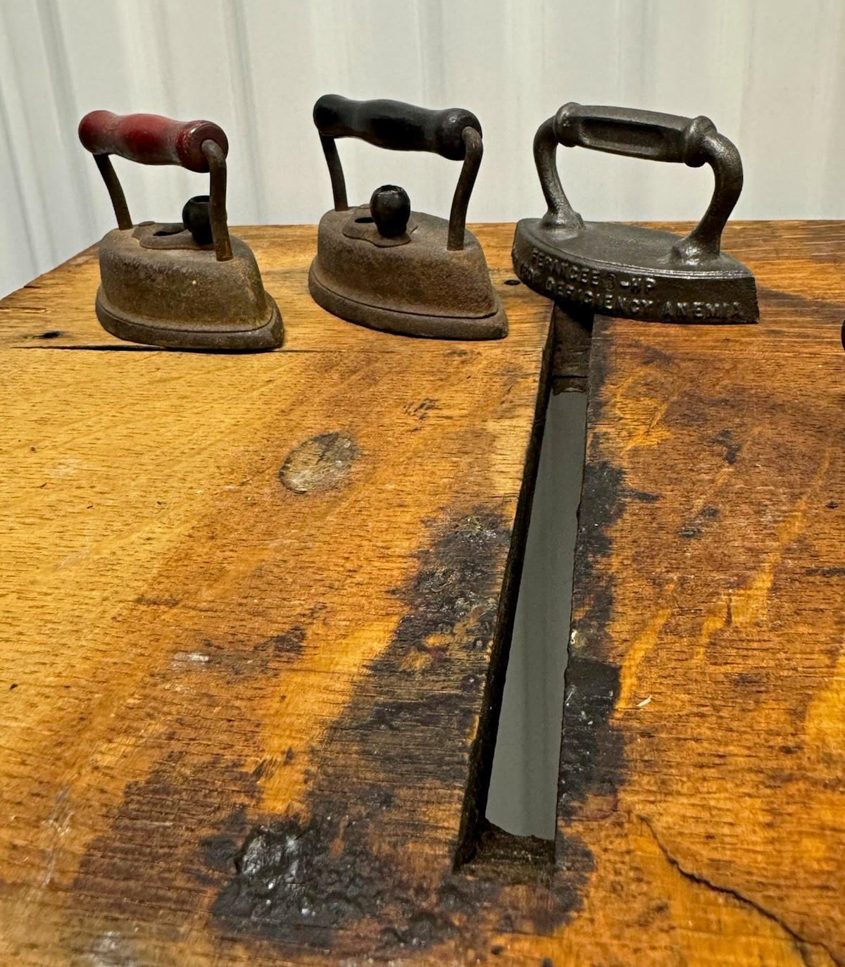 3 antique cast iron irons. And one cast iron trivet