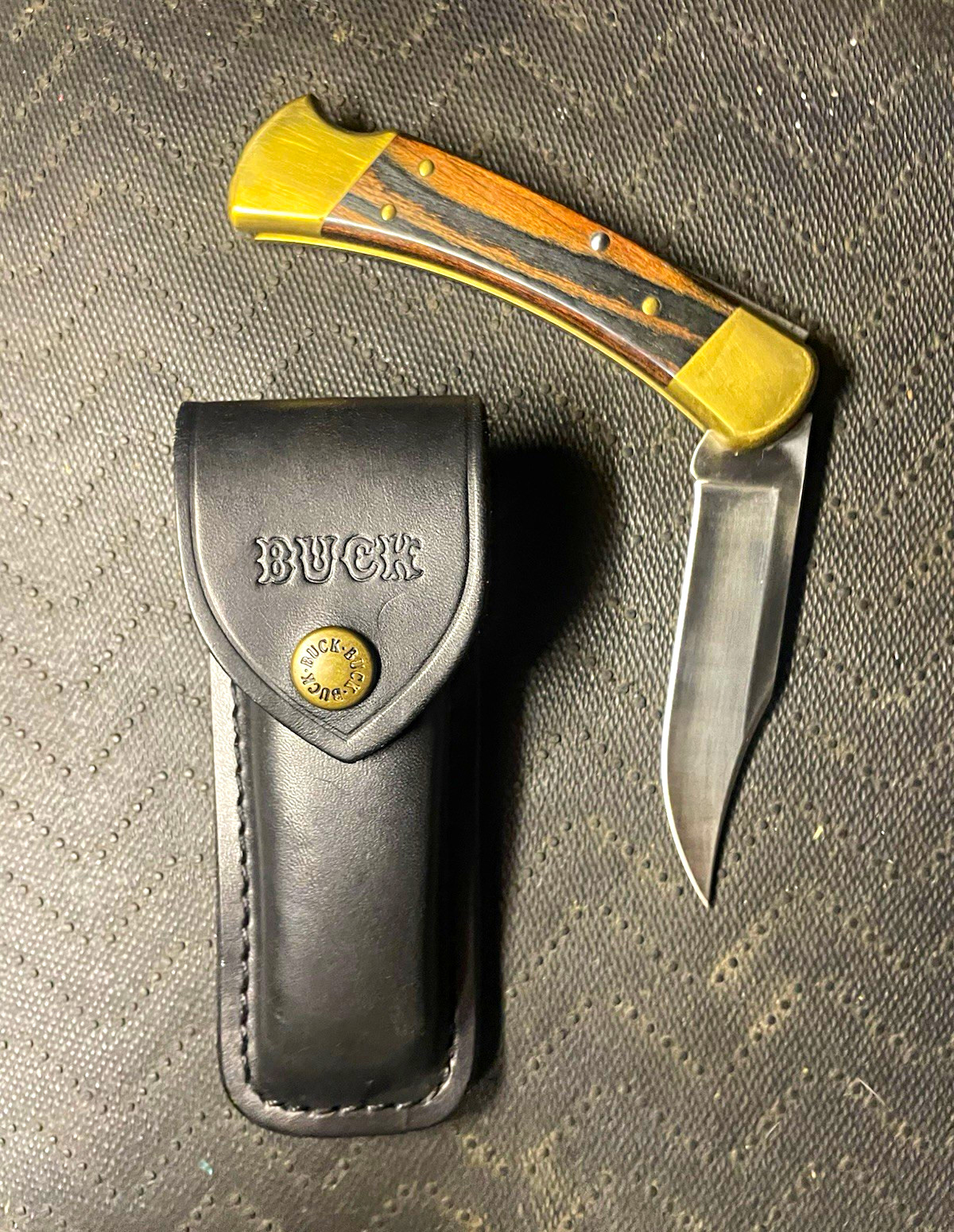 Buck 110 Folding Pocketknife Stainless Clip Point Wood/Brass Handle Sheath