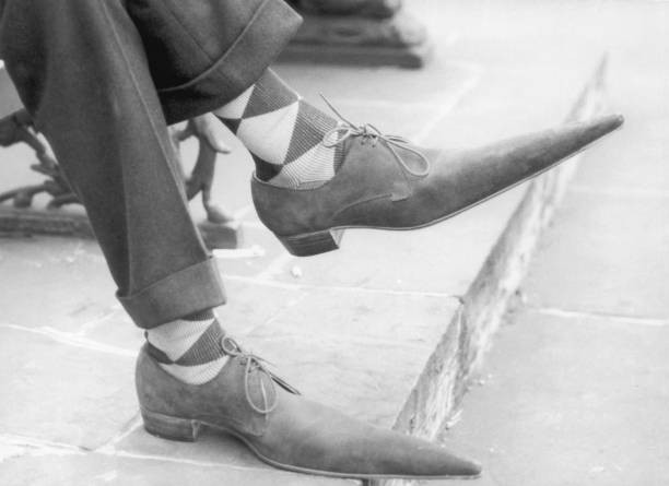 Pair of feet clad in lace up shoes with long pointy toes 1960 Old Photo