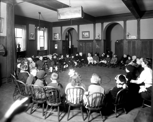 Little kids sitting in a circle in chairs circa early 1900s Old Photo