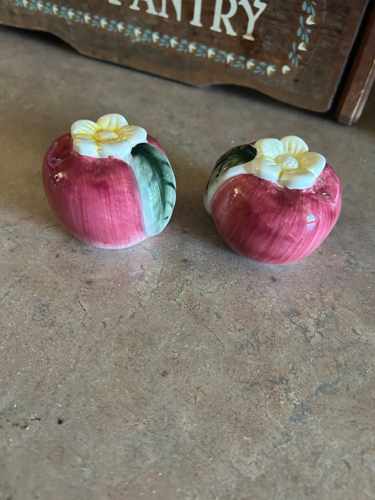 Vintage ceramic apple-shaped salt and pepper shakers with white flower and green Vintage ceramic apple-shaped salt and pepper shakers with white flower and green