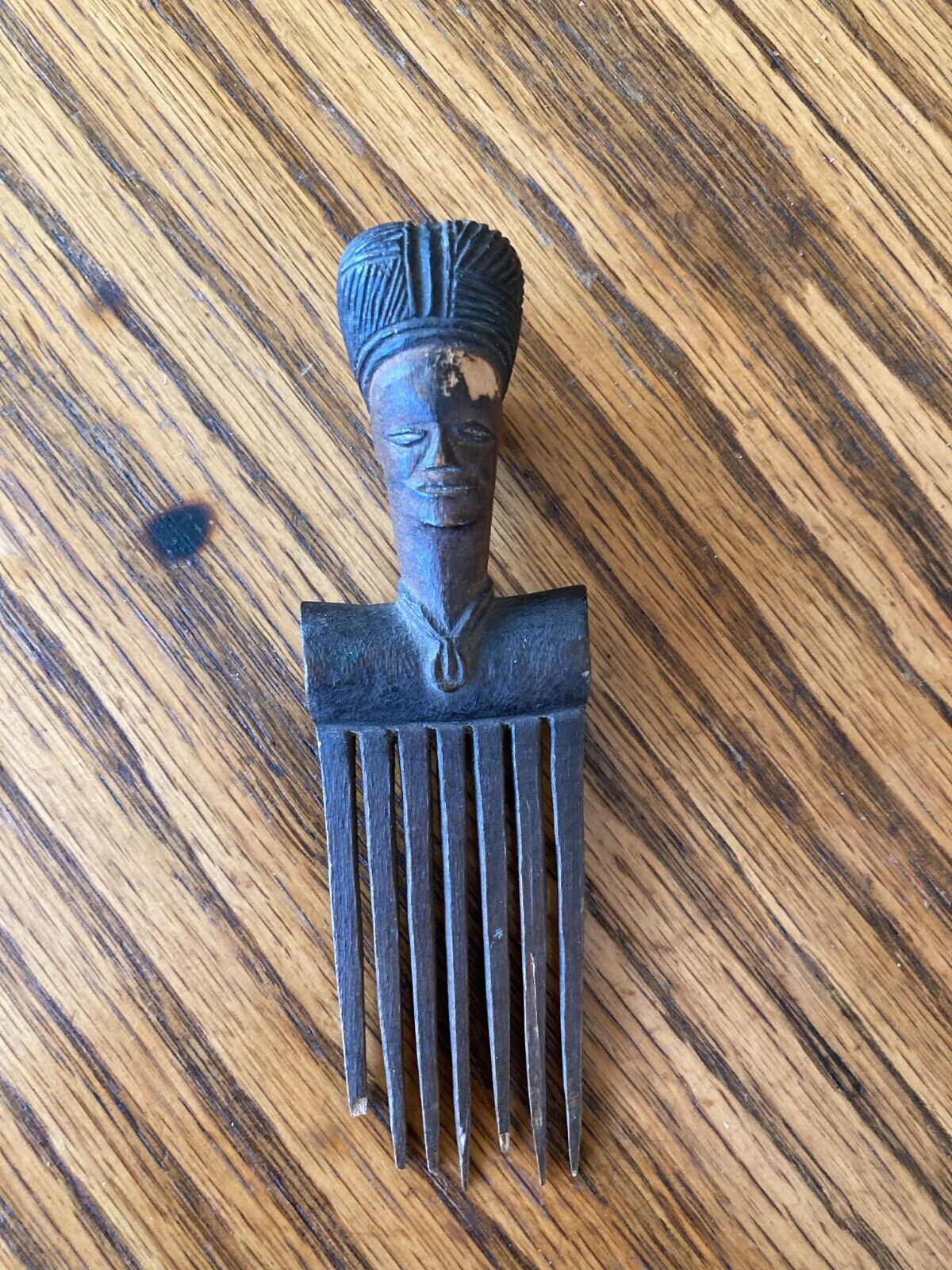 A WELL CARVED ANTIQUE AFRICAN HAIR COMB, WOMAN WITH HEADPIECE