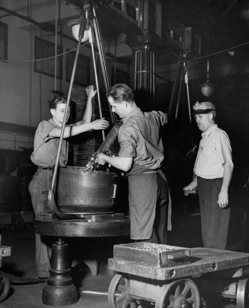 Two Mint workers supervised by a third man as they fill a weighing- Old Photo