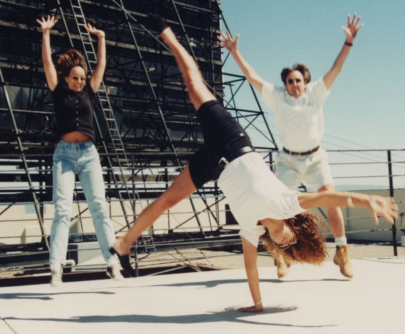 1990s Two Women Man Friends Jumping Doing Cartwheel Rooftop Playful Fun