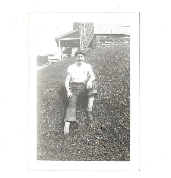 VTG B&W Found Small Snapshot Photo Pretty Girl in Pants Sitting on Grass Hill