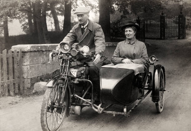 A mature couple riding a Rudge motorcycle he driving she seated si- Old Photo