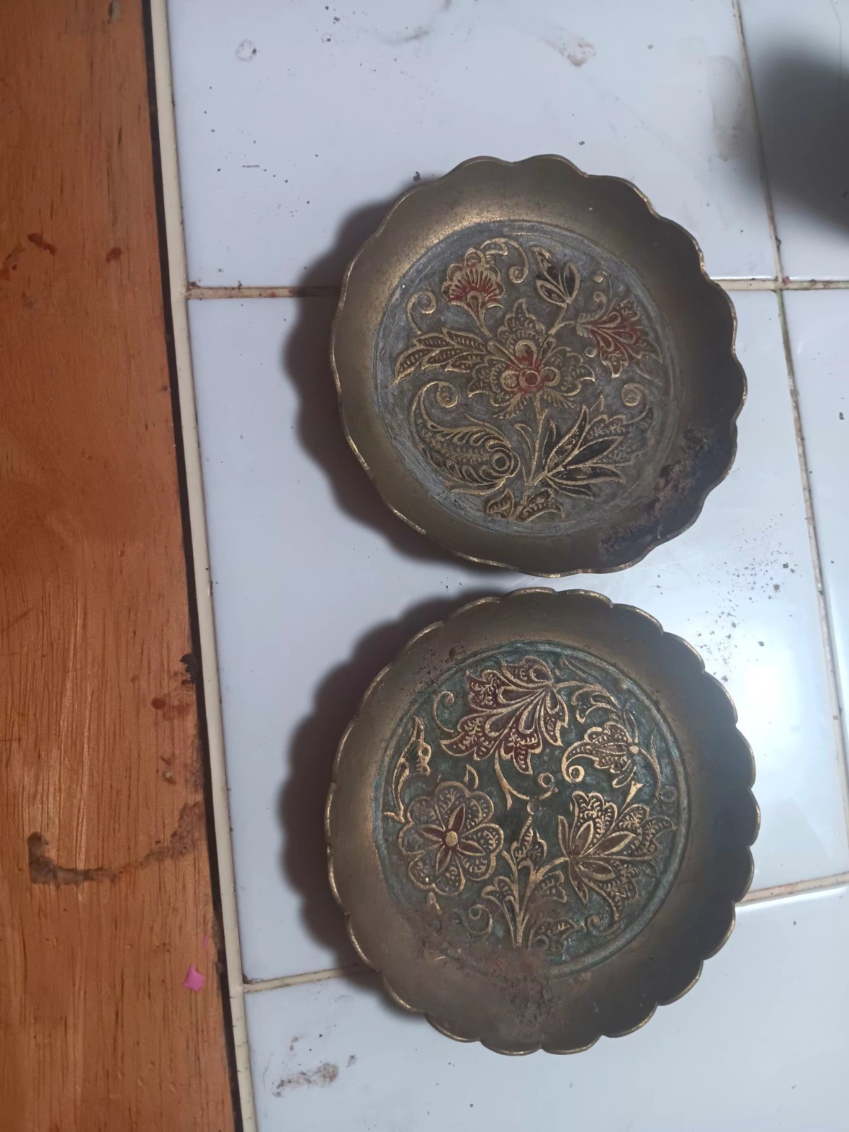 This is a vintage embossed brass plate featuring an intricate floral design