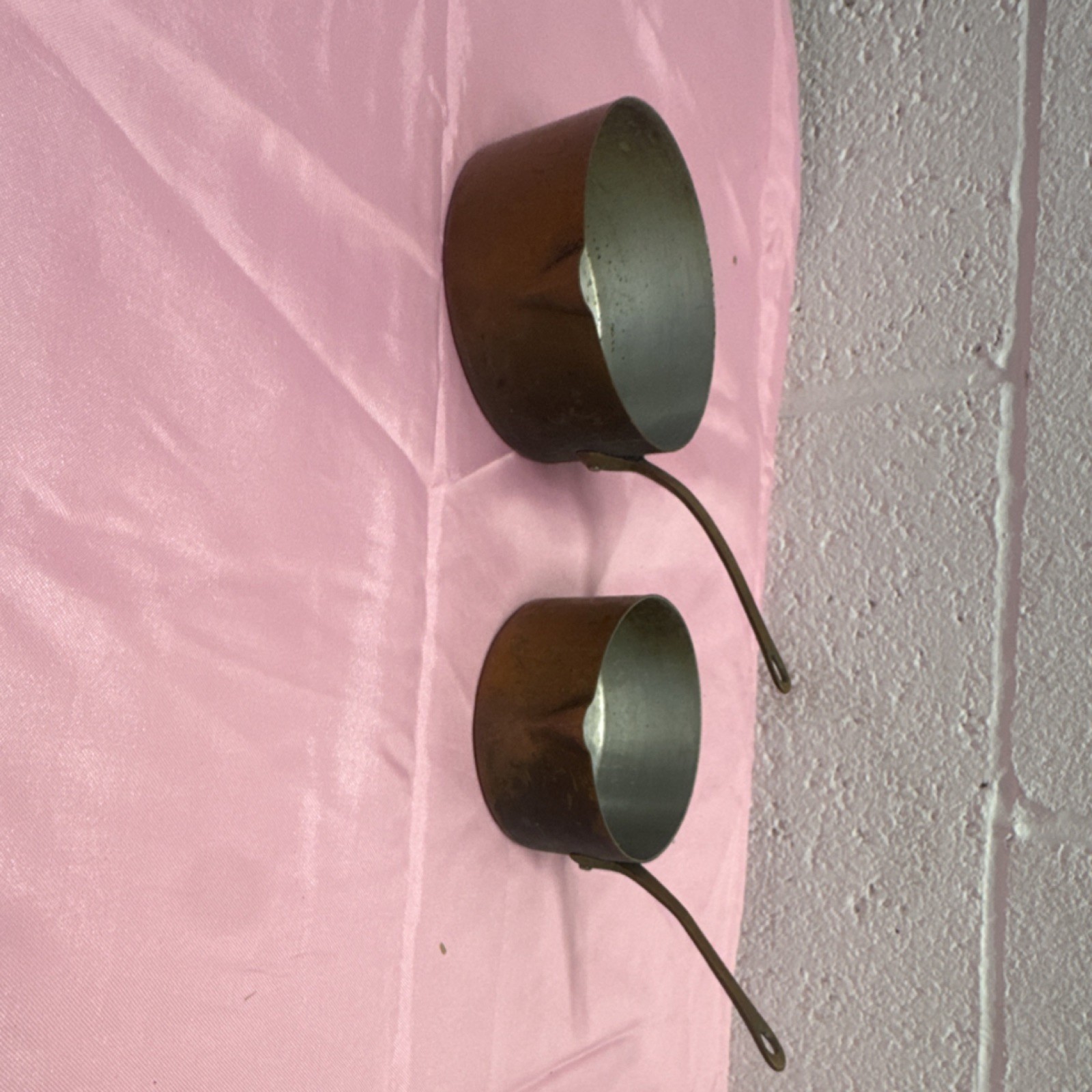 Pair of vintage French copper saucepans with long brass handles.