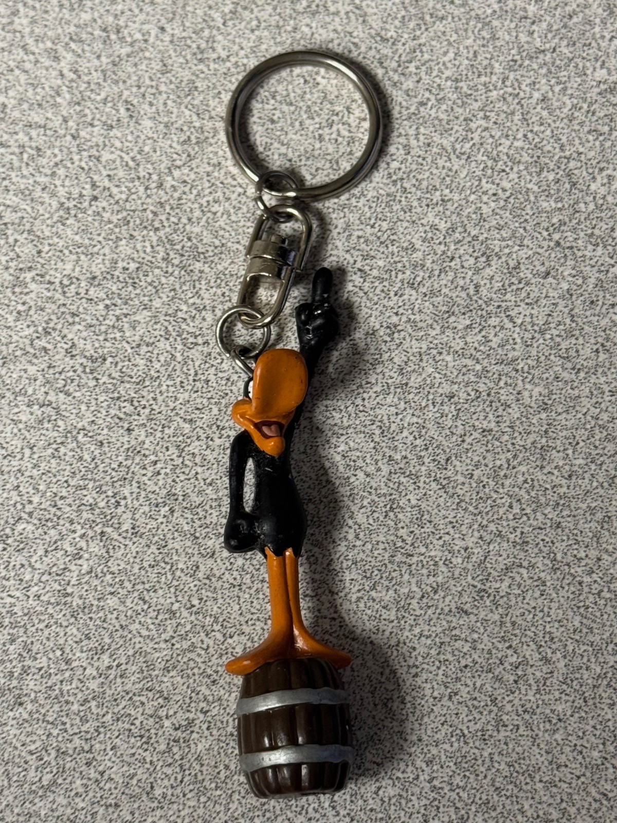 Vintage Warner Bros. Looney Tunes Daffy Duck keychain standing on a barrel
