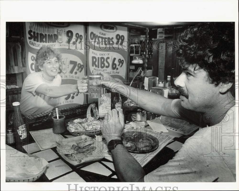 1989 Press Photo Penny Boothe serves a beer to Pat Comiskey at Tark's Restaurant
