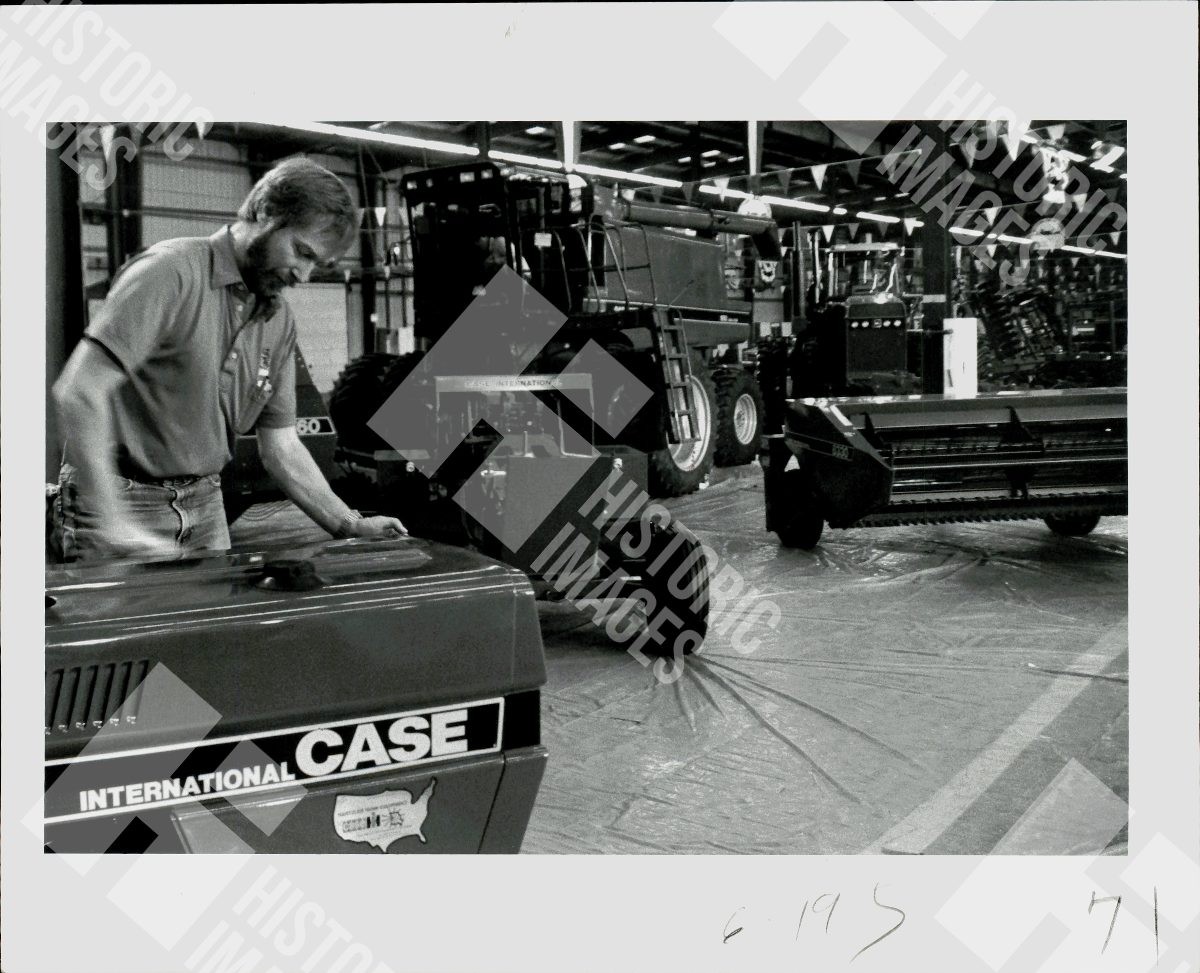 1971 Man inspecting an International Case tractor in a factory setting