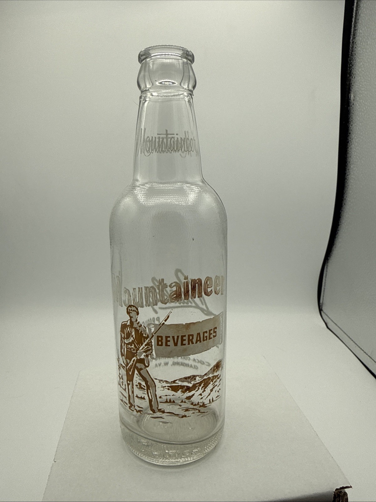 Mountaineer; Coca-Cola Bottling Co.; Clarksburg, WV; 2-color ACL soda pop bottle Mountaineer; Coca-Cola Bottling Co.; Clarksburg, WV; 2-color ACL soda pop bottle
