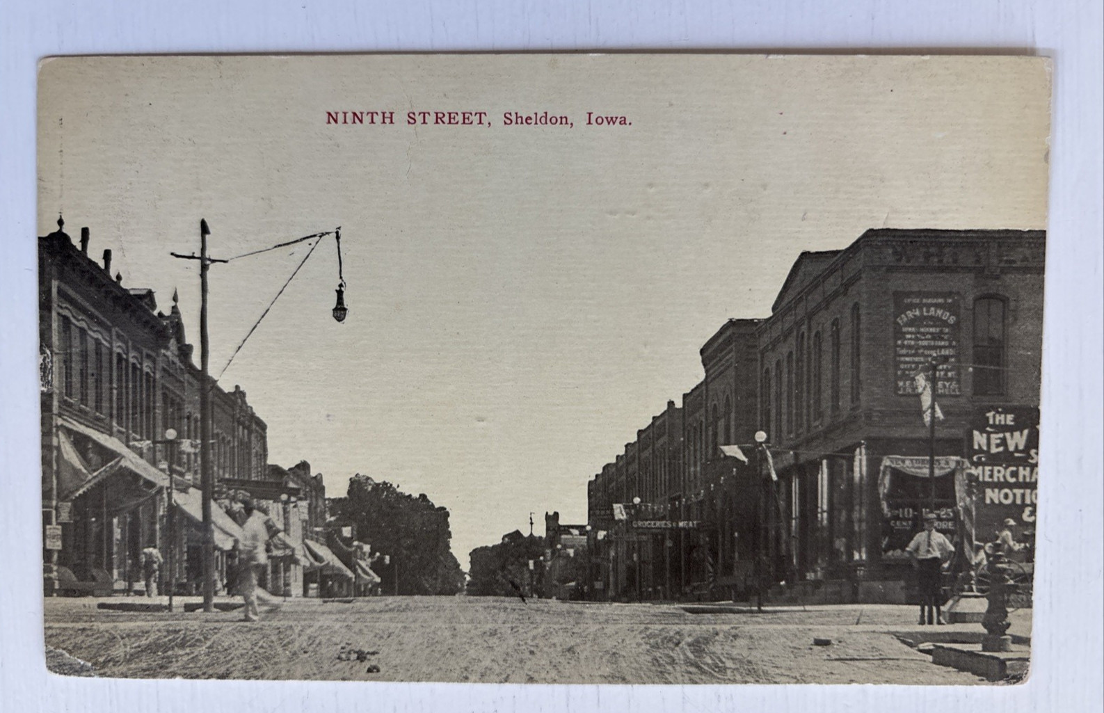 1913 Ninth Street Sheldon Iowa Street Scene Postcard Farmland Sign