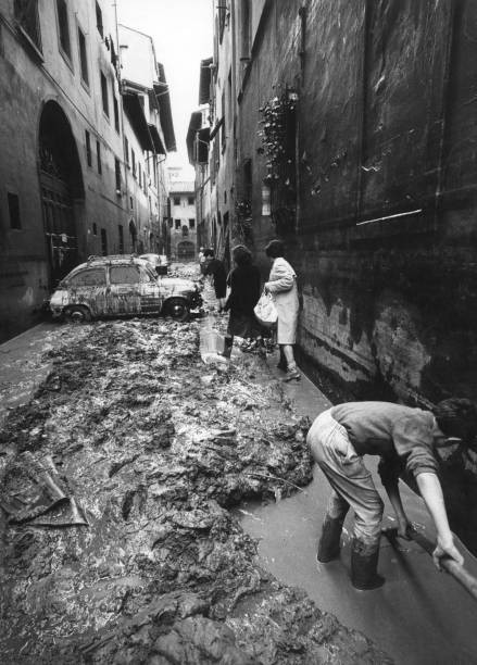 Man working drain water out of a street of Florence after flood Fl- Old Photo
