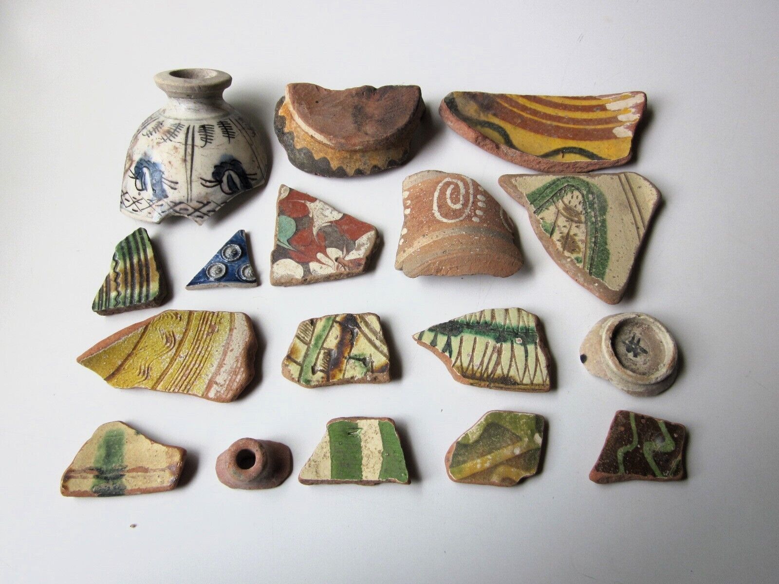 large lot of 17 ancient medieval period glossy pottery with floral motifs .