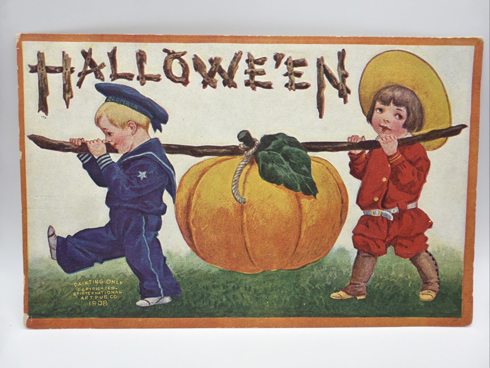 Embossed Halloween Postcard Boy Sailor Suit and Girl Carrying Giant Pumpkin