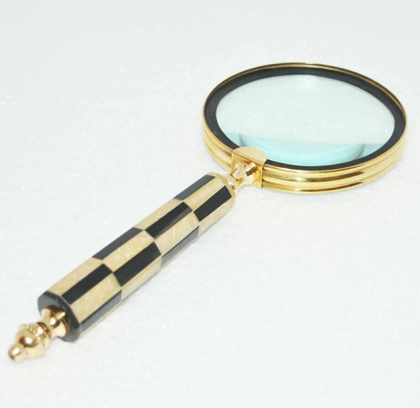 An antique, vintage brass maritime magnifying glass with a sturdy resin handle