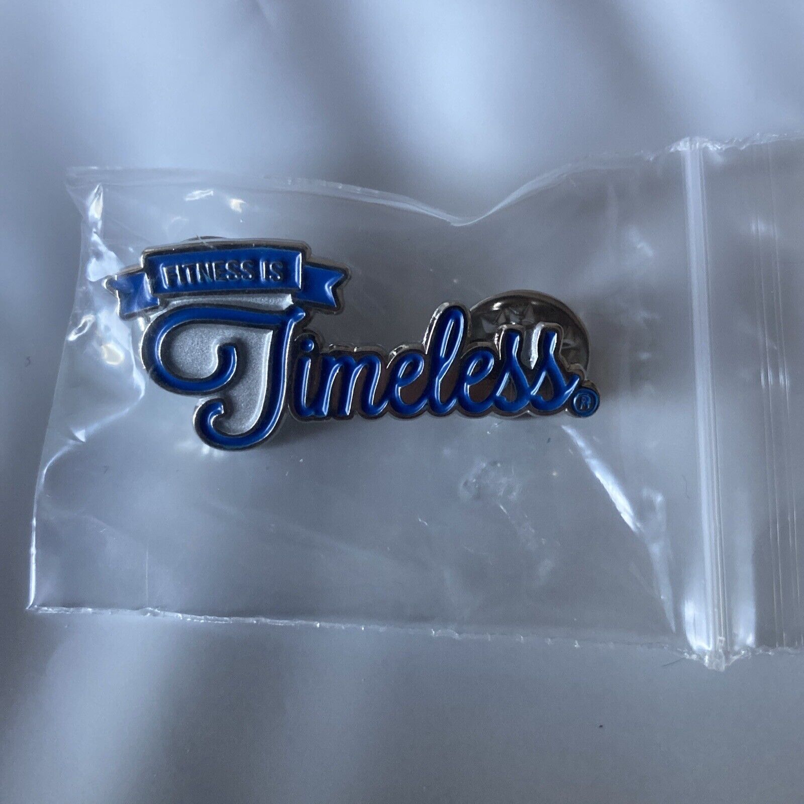 Fitness Is Timeless Lapel Pin Silver with Blue Lettering