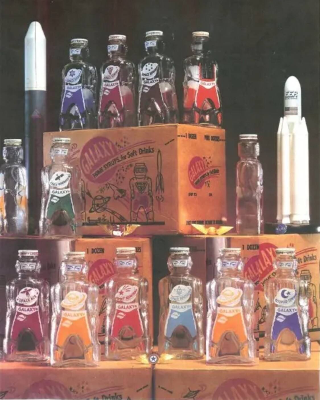 12 GALAXY SPACE FOODS  SPACEMAN   ASTRONAUT SODA SYRUP  BOTTLE COIN BANKS 1953