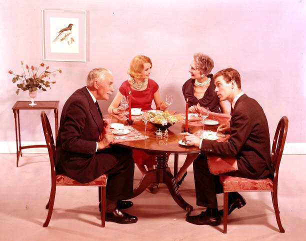 Posed studio portrait of a family of two generations seated a dini- Old Photo