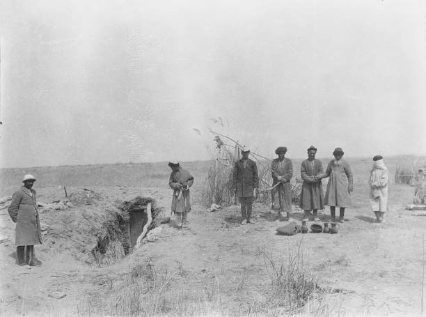 People standing around with what looks like hole in ground on left .. Old Photo