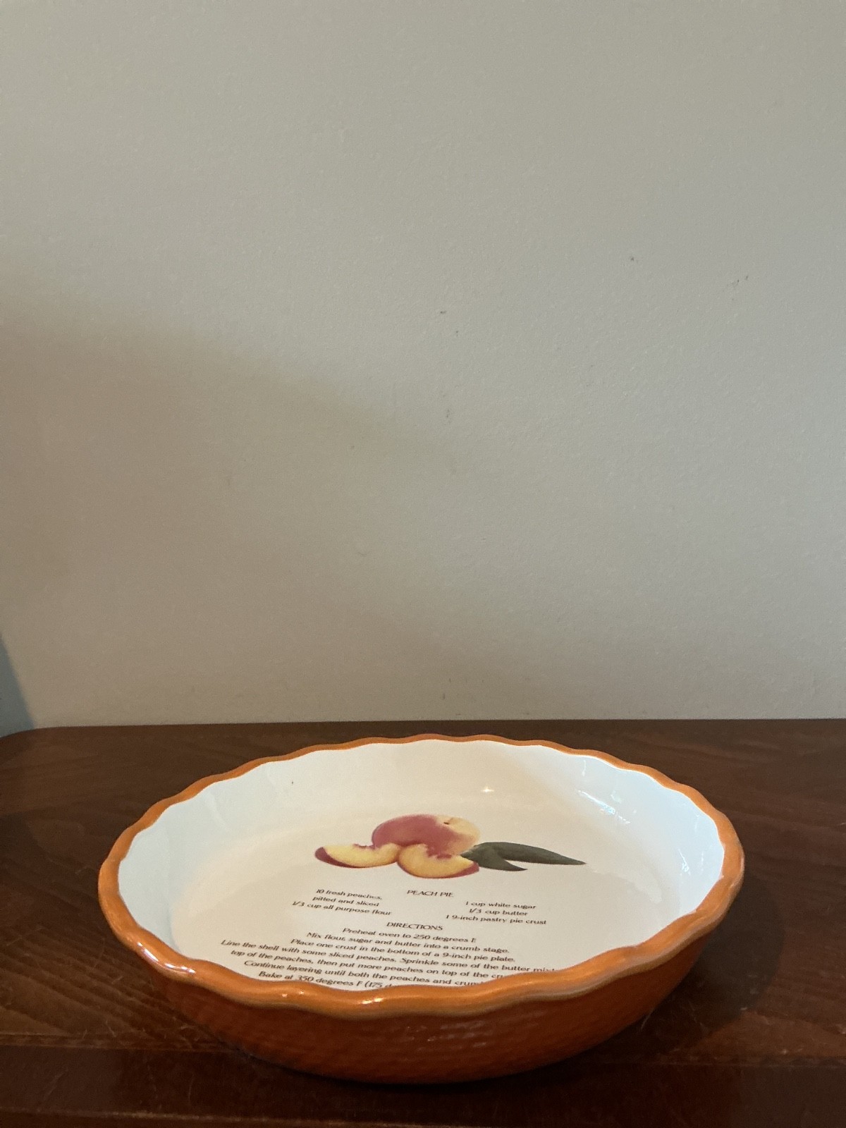 ceramic peach pie recipe plate with a hand-painted orange fluted edge
