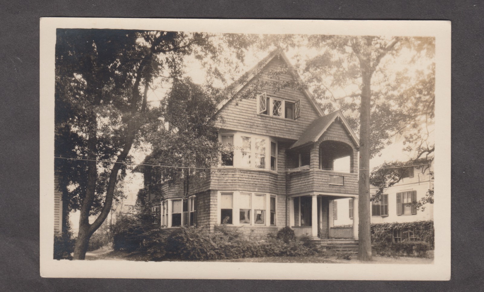 Historic, multi-story Shingle-style house. Vintage RPPC Postcard. Sepia.