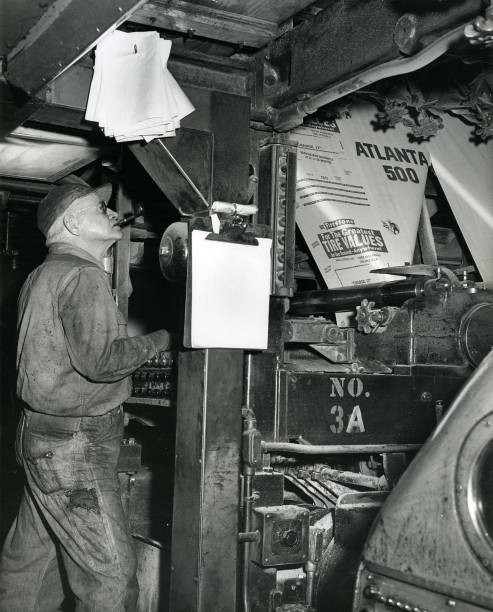 Worker uses a printing press produce posters an upcoming Atlanta 5- Old Photo