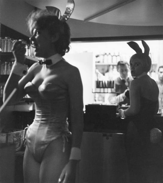 Two Playboy bunnies work Playboy Club one seen having a snack whil- Old Photo
