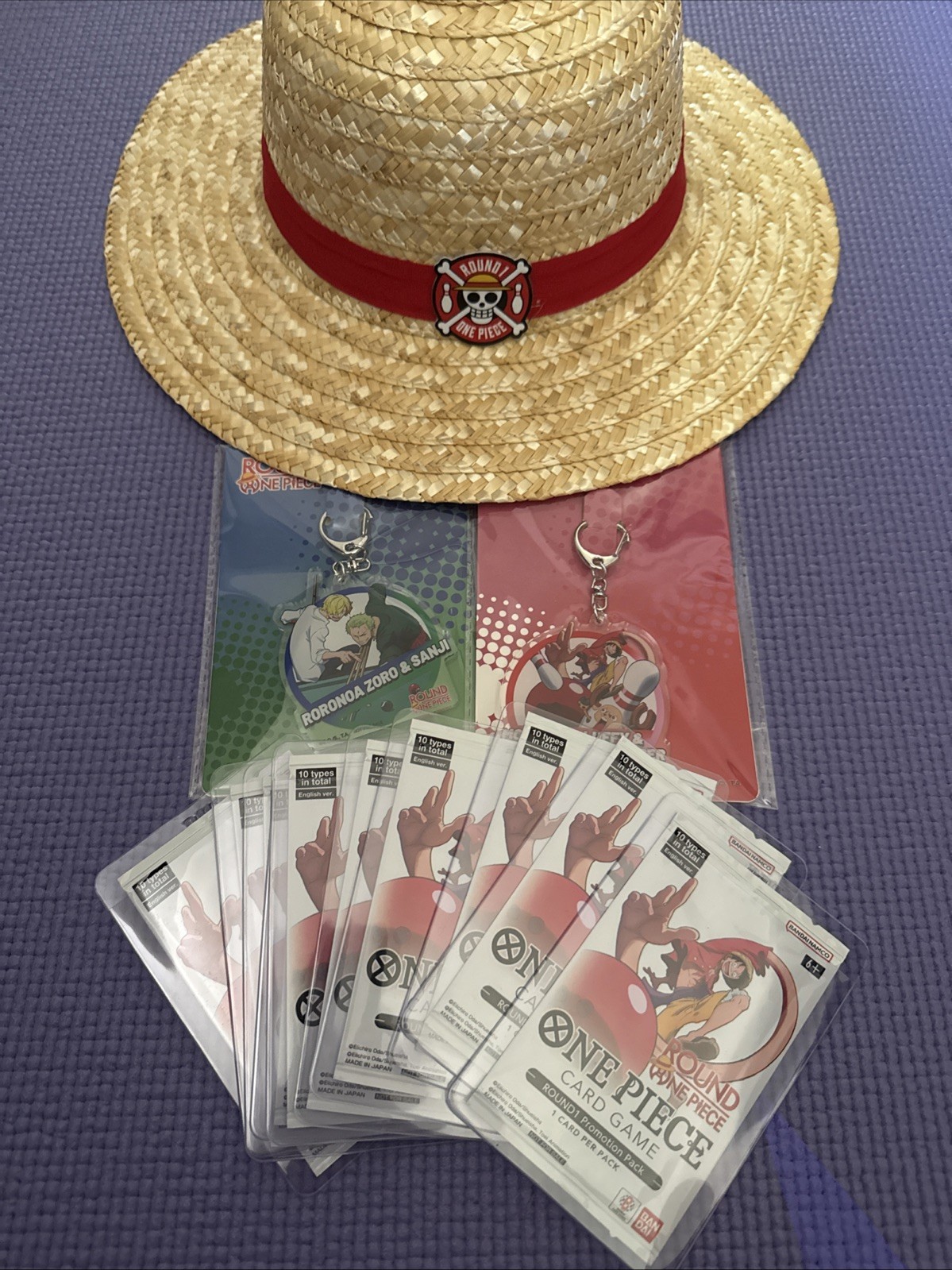 Round1 One Piece TCG Promo Bundle 10 Sealed Packs, Straw Hat, 2 Keychains Round1 One Piece TCG Promo Bundle 10 Sealed Packs, Straw Hat, 2 Keychains