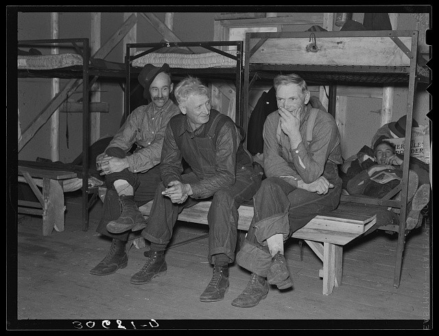 Lumberjacks in their bunkhouse after dinner. Logging camp near Effie, Minnesota
