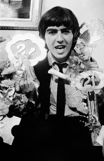 Beatles guitarist George Harrison posing some gifts that fans s- 1964 Old Photo