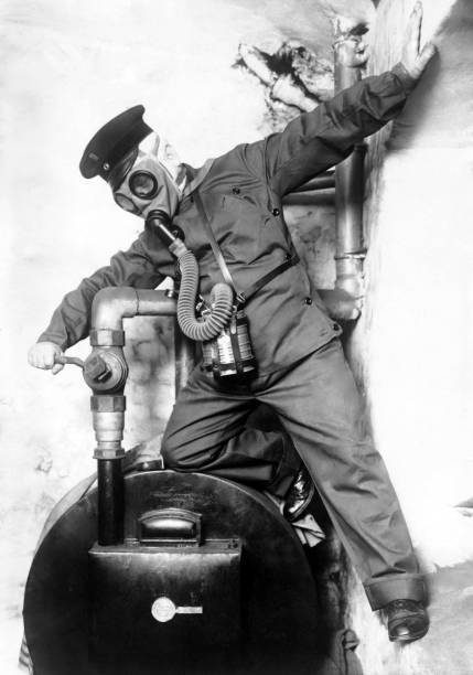 A Worker equipped with a gas mask is testing a new machine set to - Old Photo