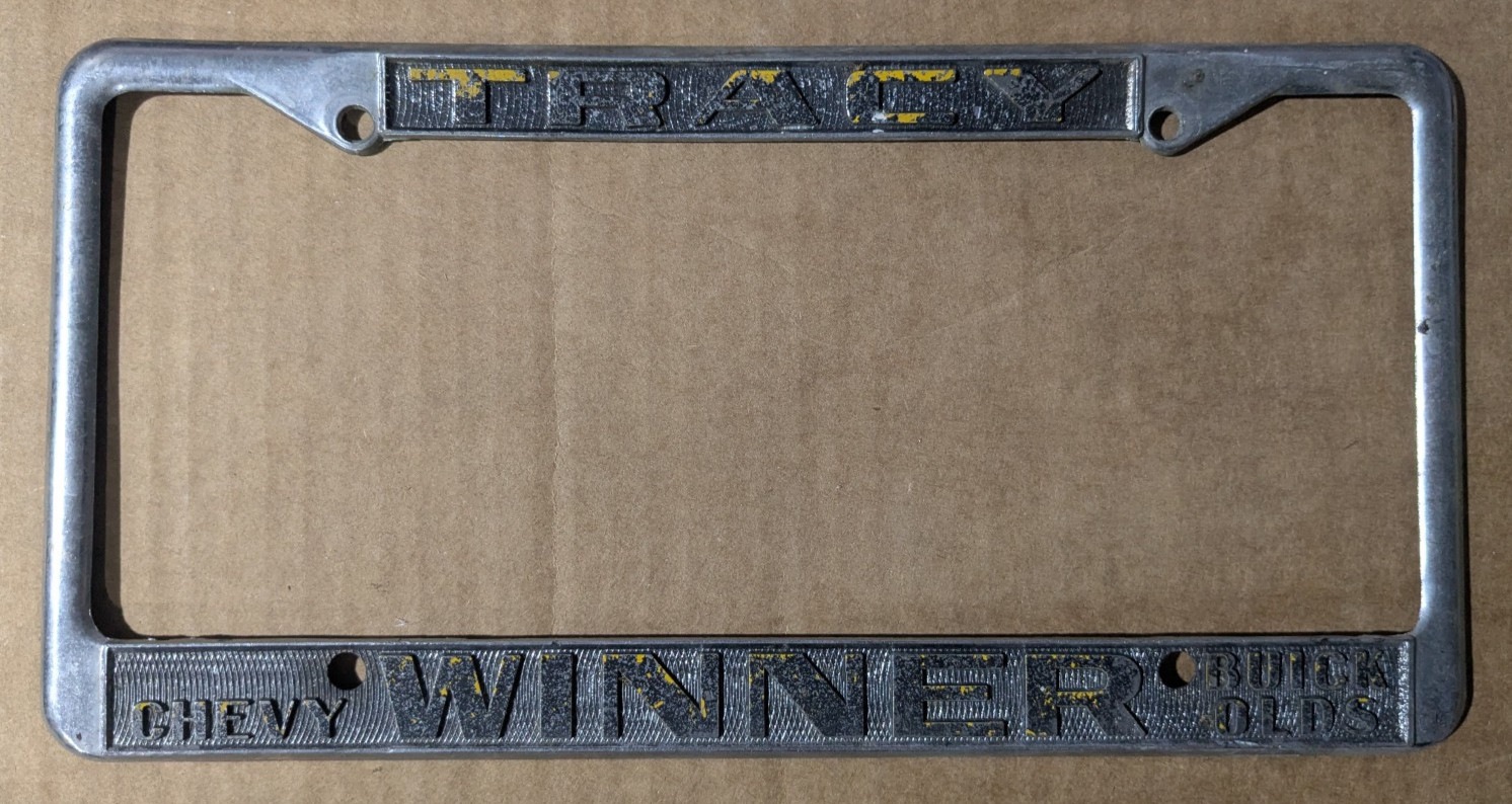 VTG Metal Tracy CA Winner Chevy Buick Olds Embossed Dealer License Plate Frame