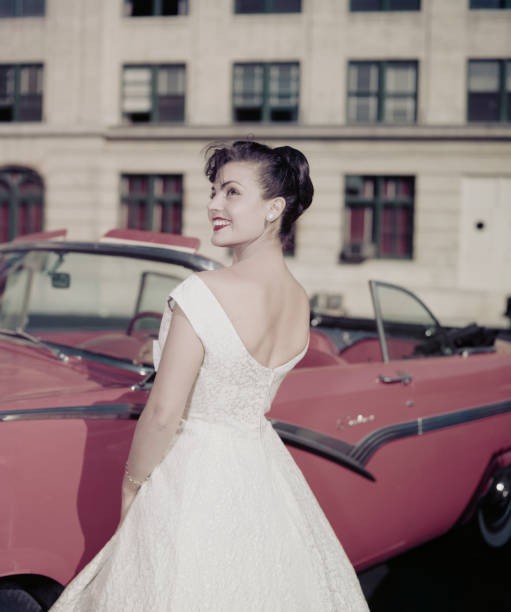 Woman modelling women\'s fashions smiling as she looks over shoulde- Old Photo