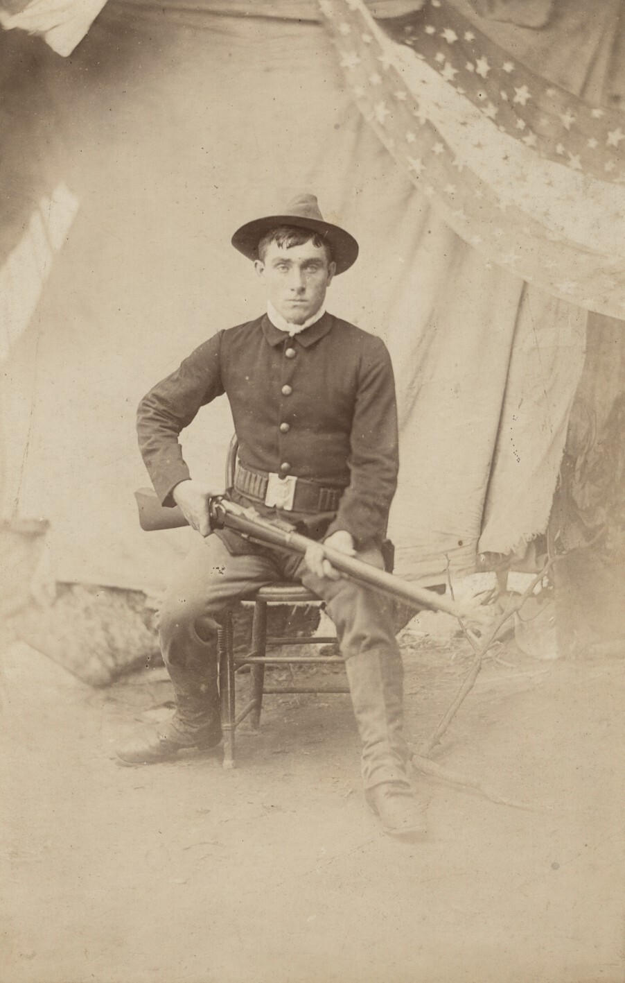 c. 1870\'s American Soldier Seated with Rifle, Star Banner in Back Photograph c. 1870\'s American Soldier Seated with Rifle, Star Banner in Back Photograph