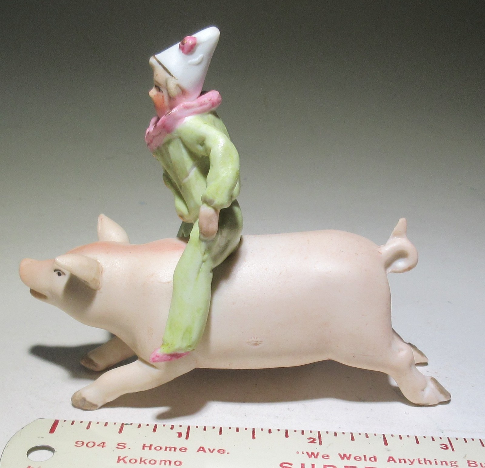 Vintage bisque clown riding pig figure